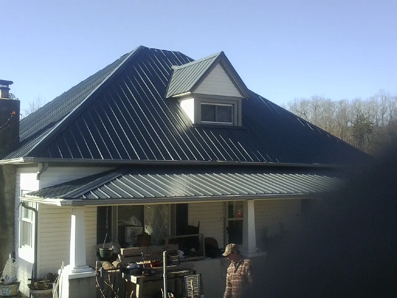 Dark blue standing seam metal roof with a dormer above a front porch in Liberty Hill