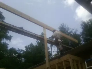 Carpenter setting a ridge beam over a new addition frame — Ice Dam Removal by Roofing Brothers in Liberty Hill