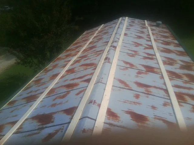 Rusted metal roof panels with new wood purlins before replacement — Storm Damage Roof Repair in Liberty Hill by Roofing Brothers